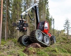 New Wheeled Harvester working in front of woods